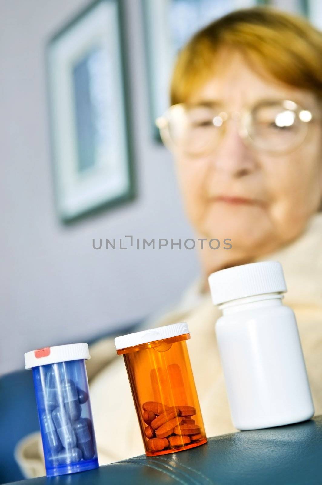 Elderly woman looking at pill bottles with medication