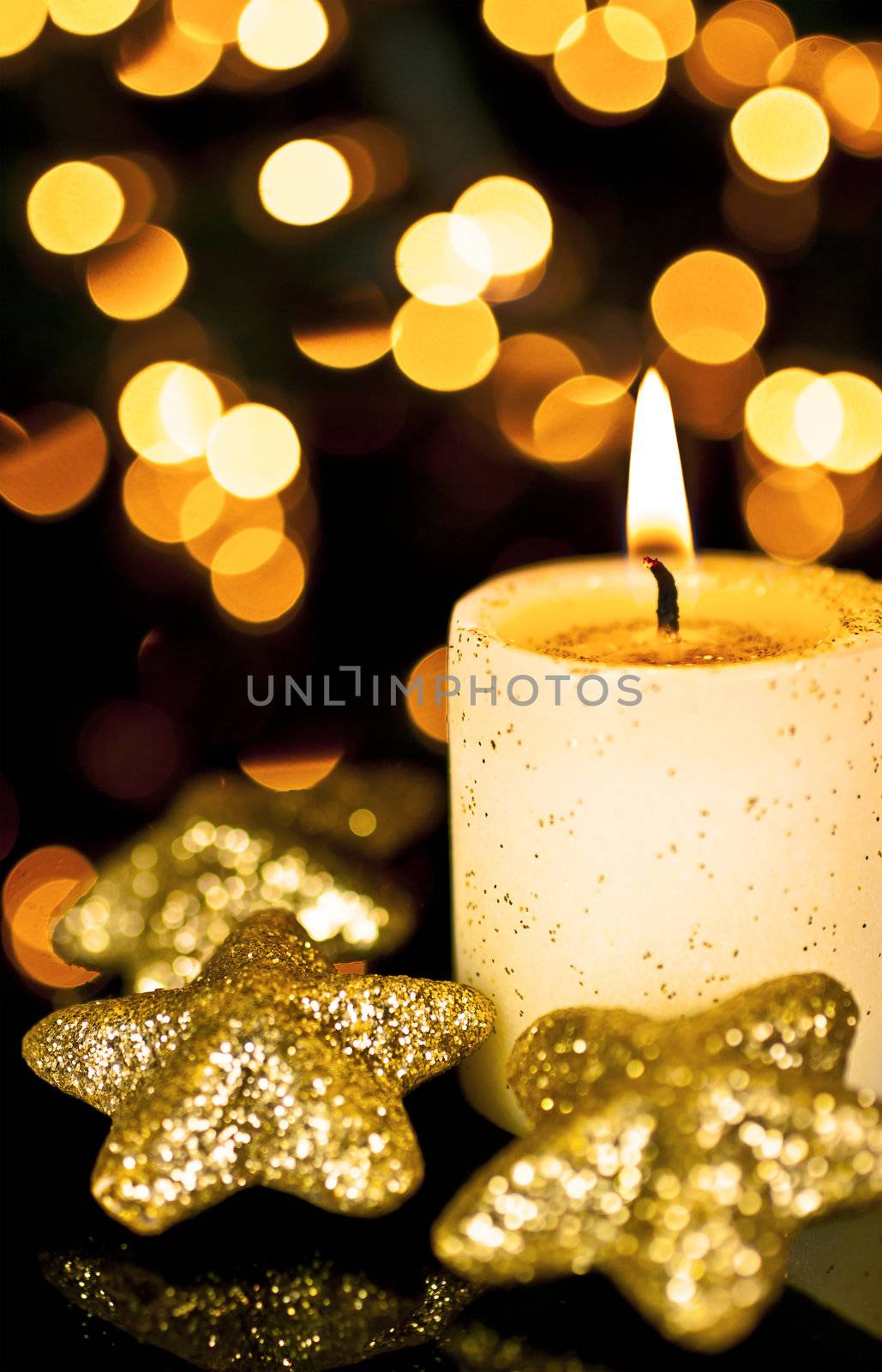 Candle with a star on a black background, back background Bokeh lights.