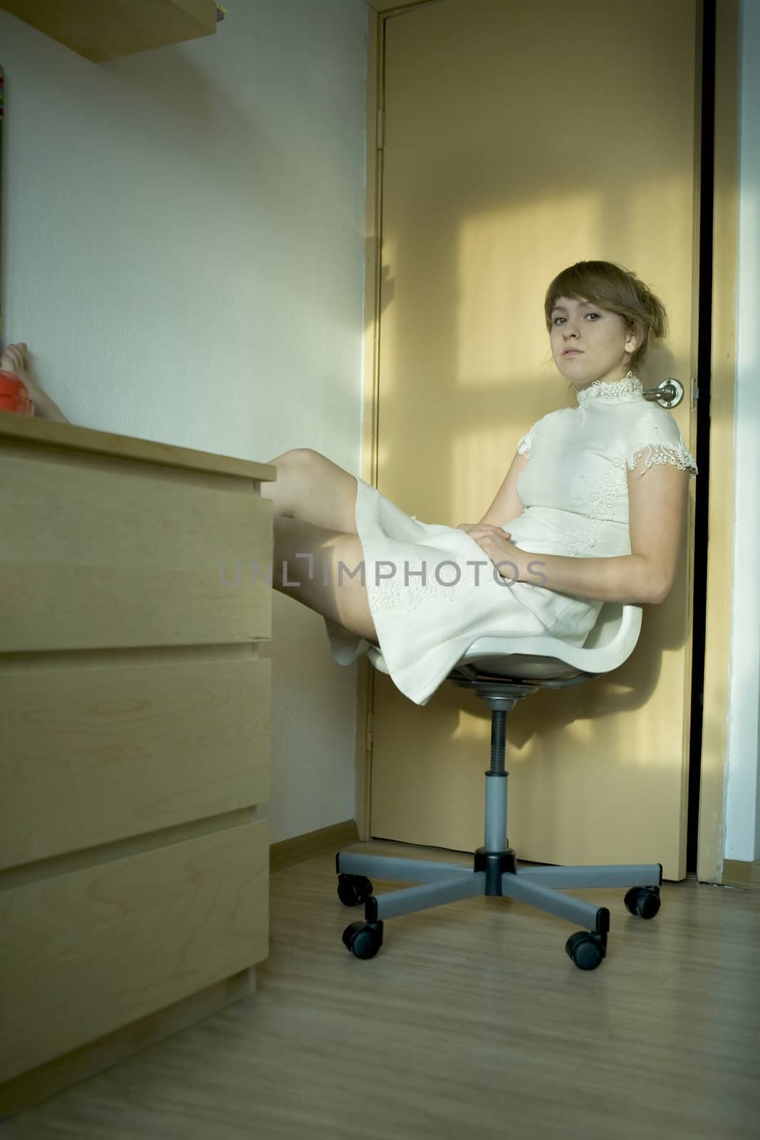 portrait of thoughtful young girl wearing white dress sitting on the chair. First love. 