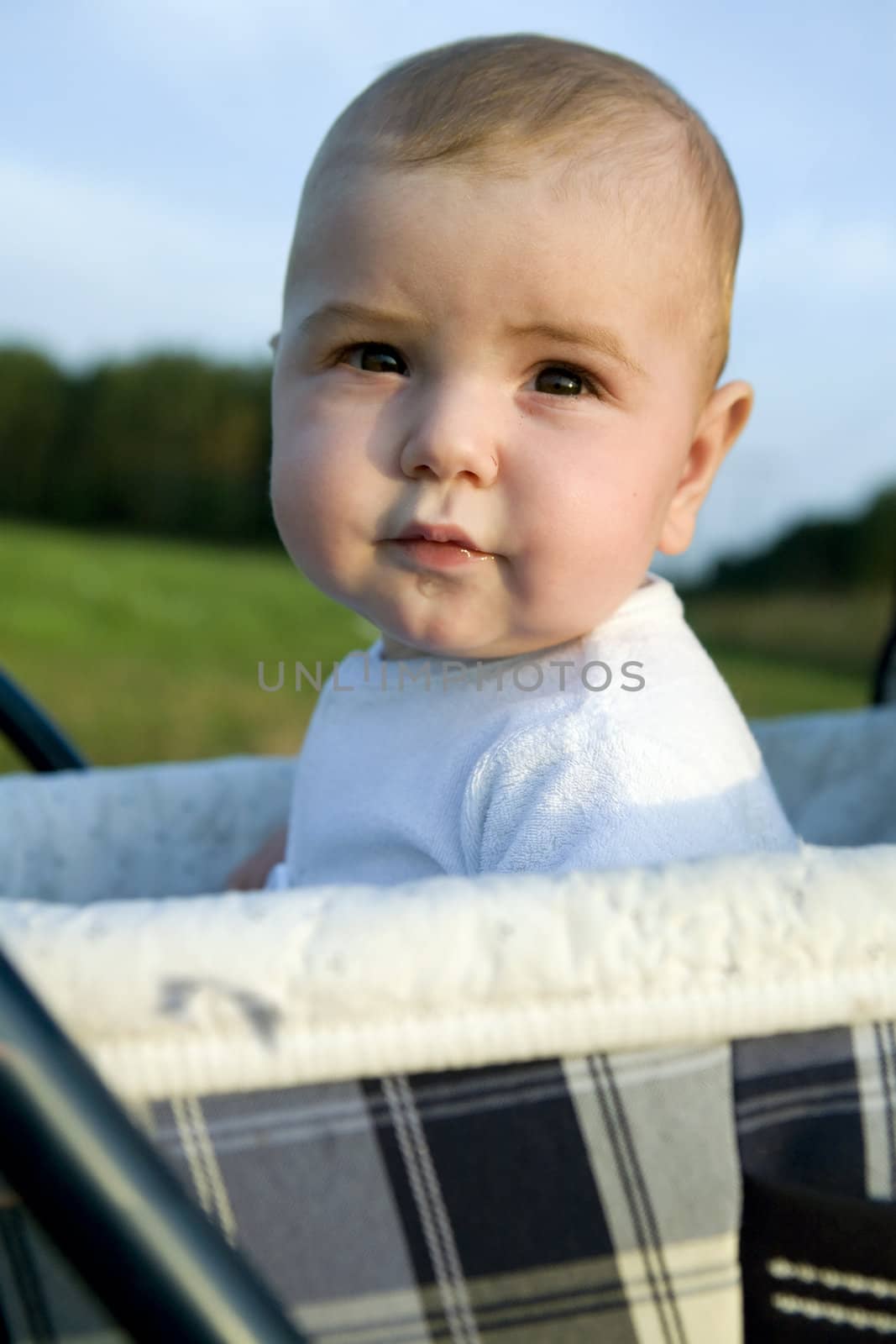 little cute boy six month old sitting on buggy