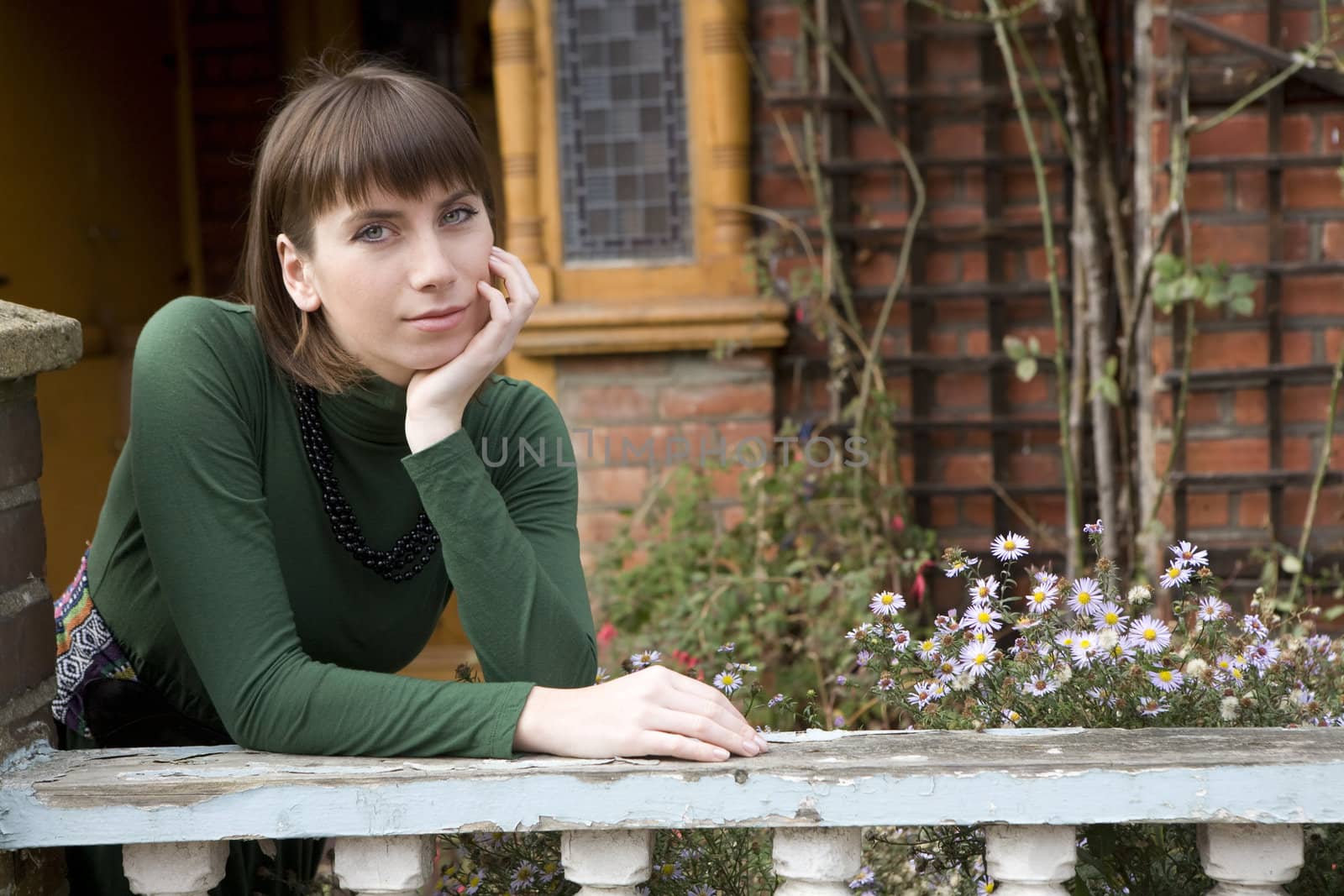 young attractive woman with beads standing in garden
