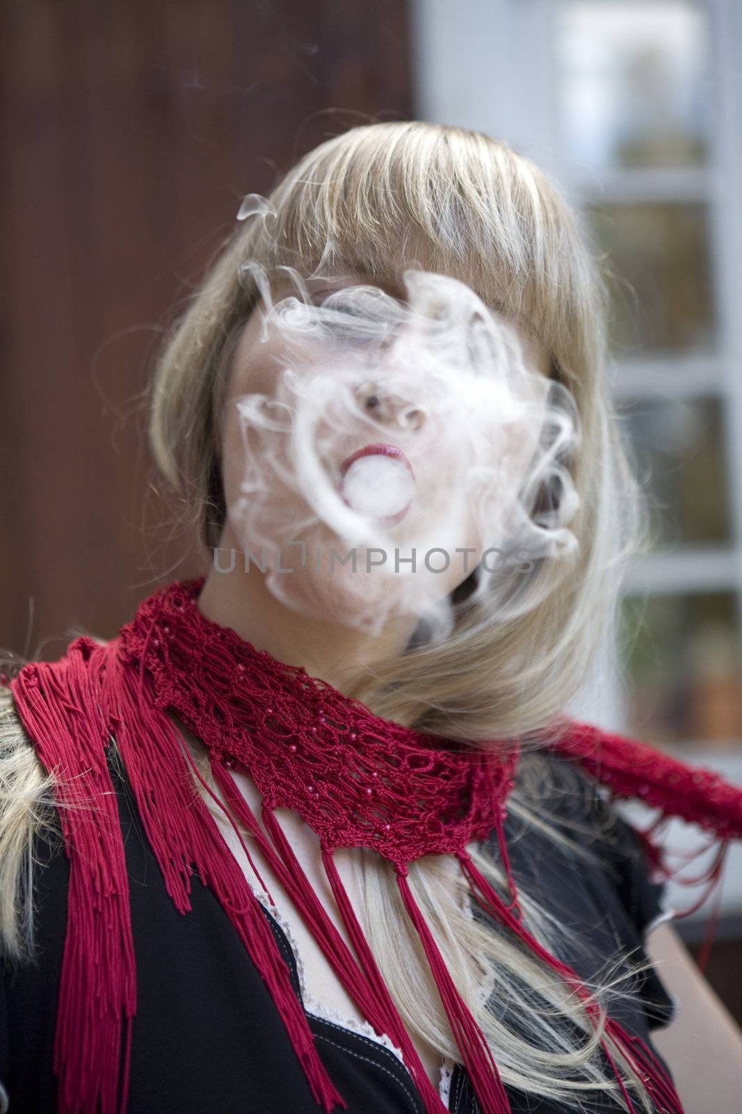 Blond woman breathe out smoke