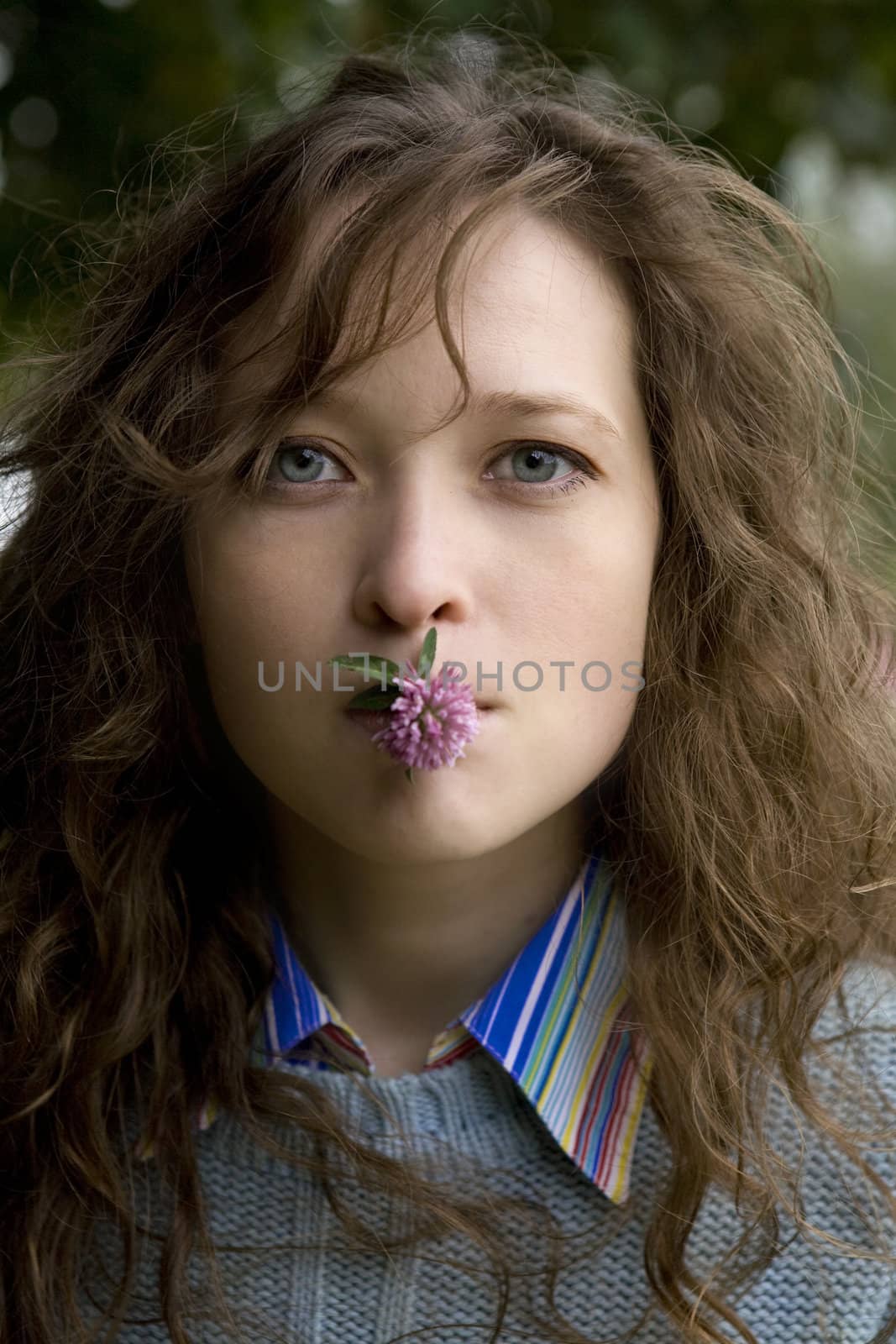 young attractive woman with clover in mouth by elenarostunova