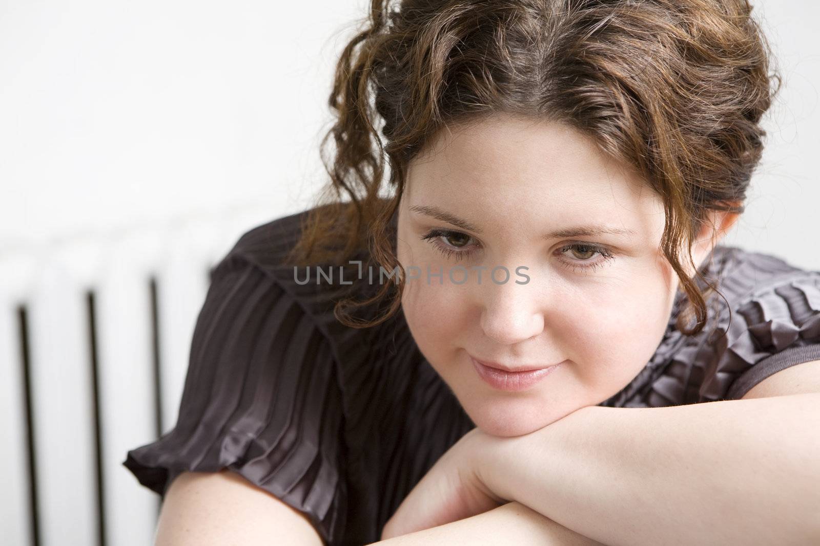 Young attractive smiling woman put head on hand