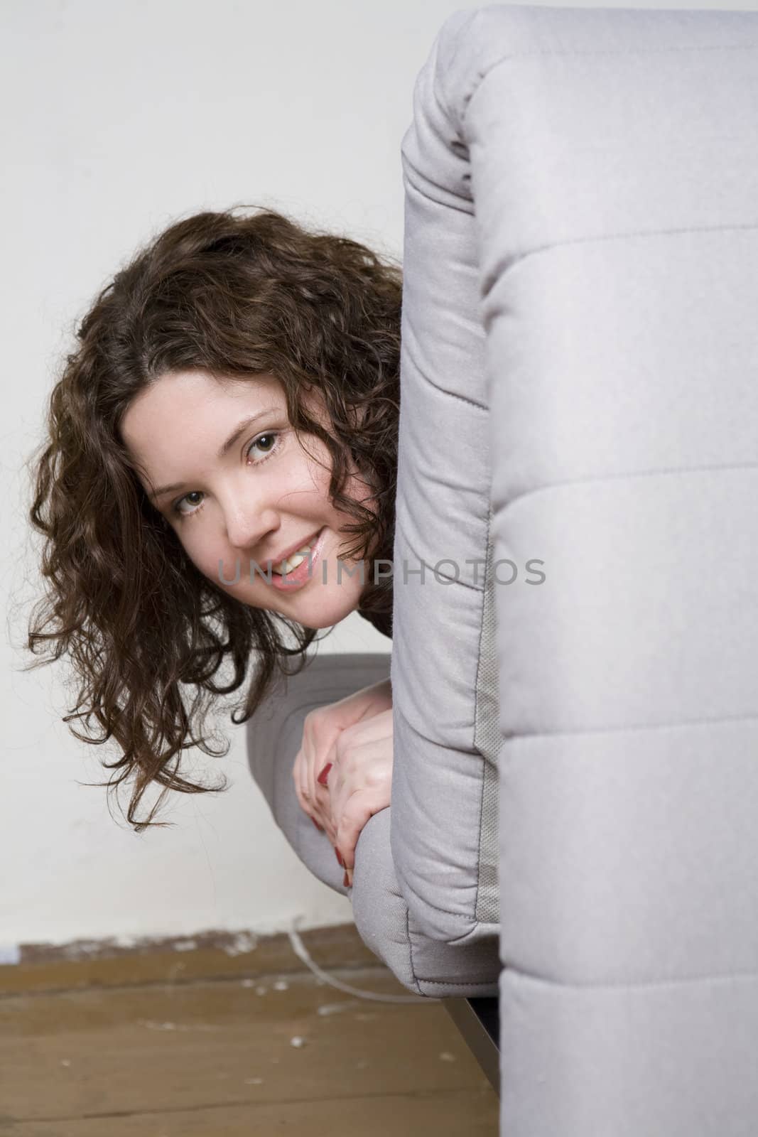 Portrait of young adorable smiling woman lying on sofa and looking camera