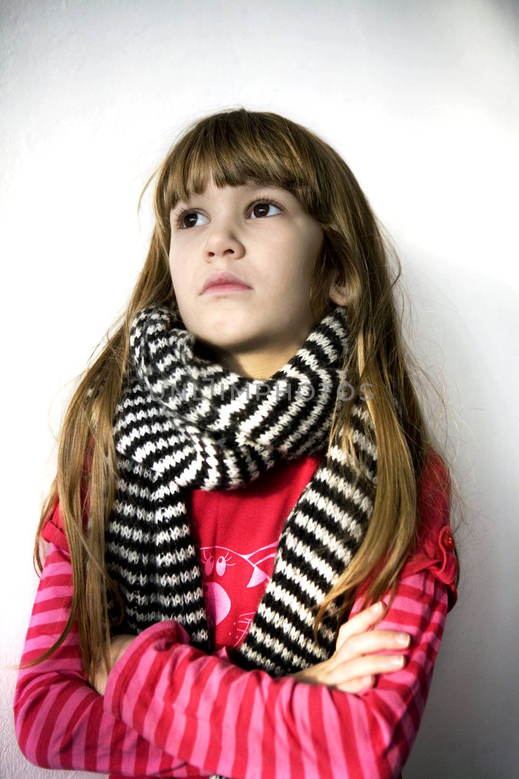 portrait young little serious cute girl with sore throat wearing red t-shirt in scarf