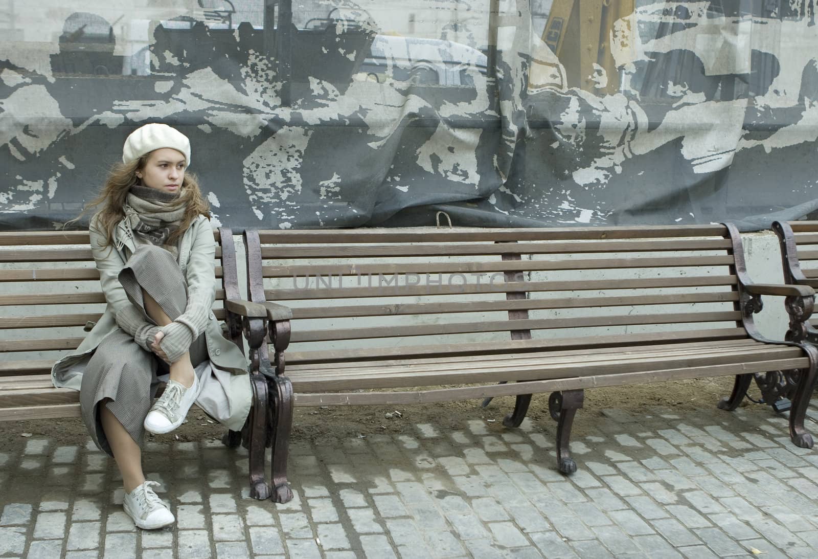 thoughtful teen girl wearing beret sitting on the bench