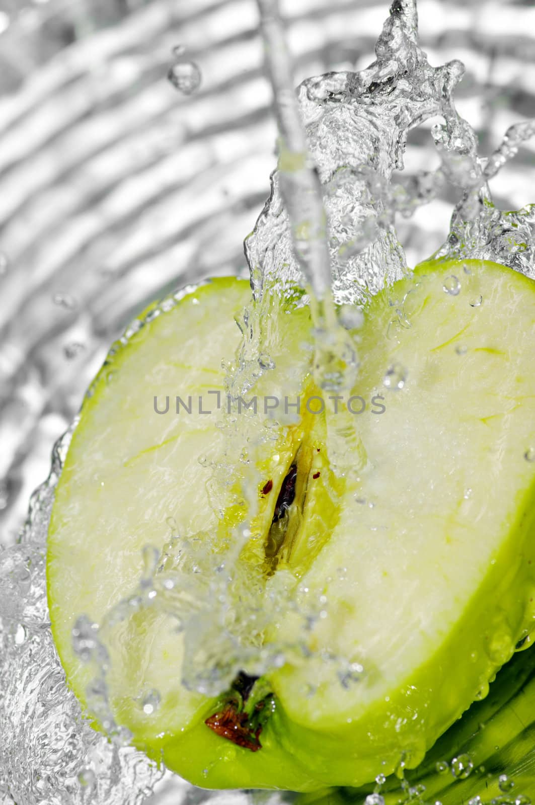 fresh water splash on green apple on metal background