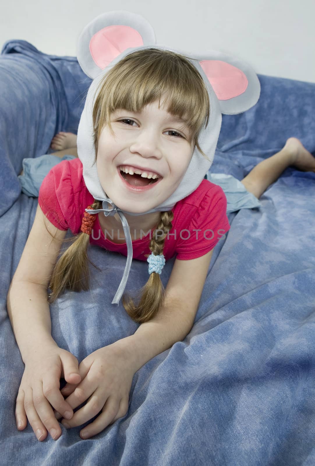 little girl wearing mouse`s ears laugh