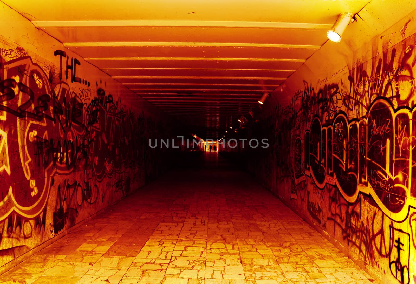 underground tunnel; red, white black colours; blurred figures in background