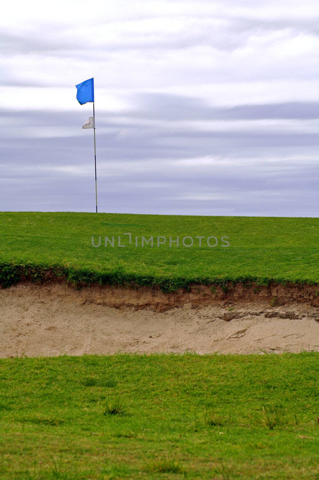 golf course; sand ditch, blue flag on post