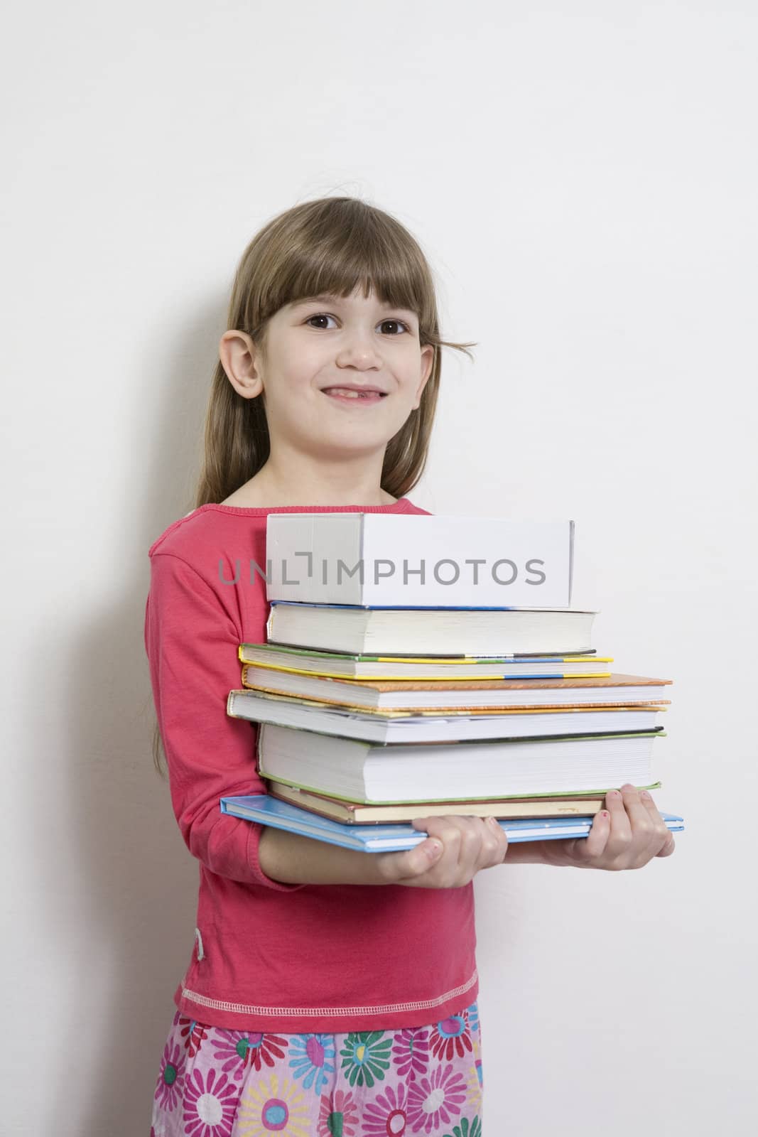 little cute girl seven years old  carry books. White background