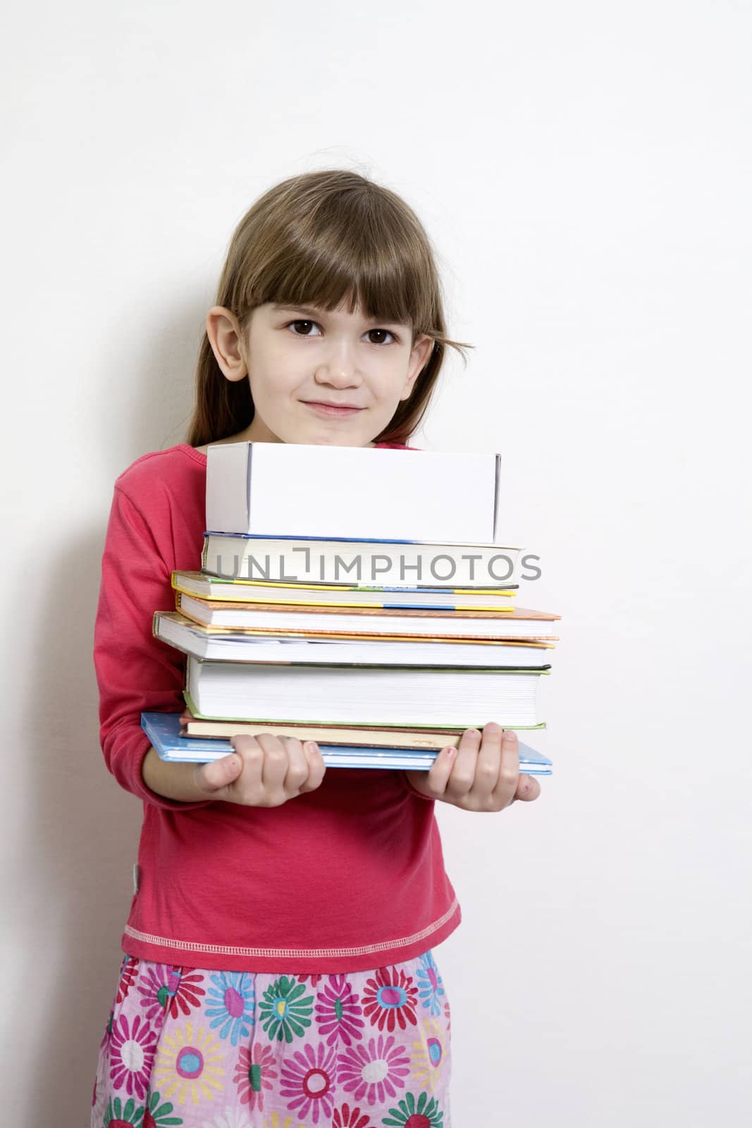 little cute girl seven years old  carry books. White background