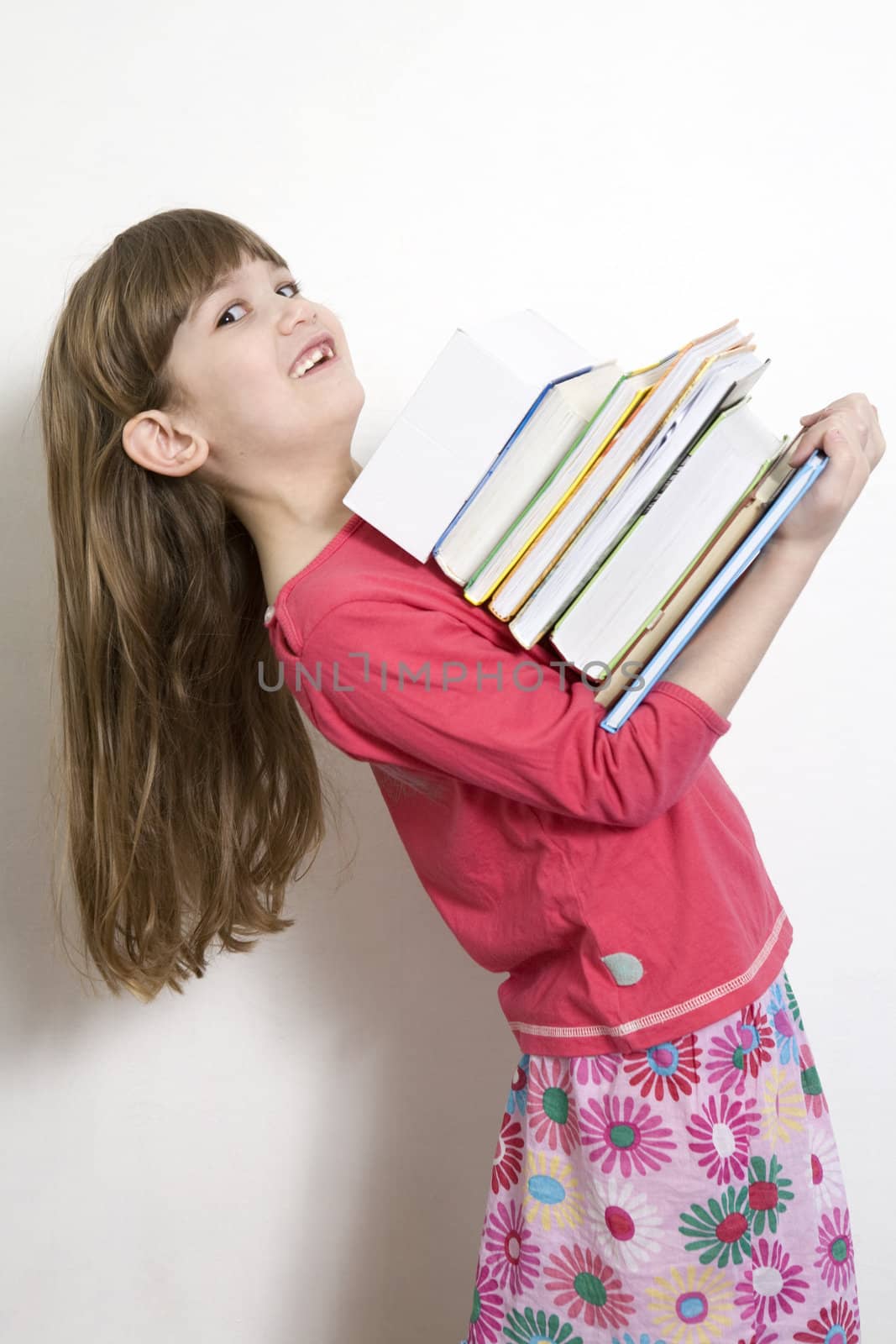 little cute girl seven years old  carry books. White background