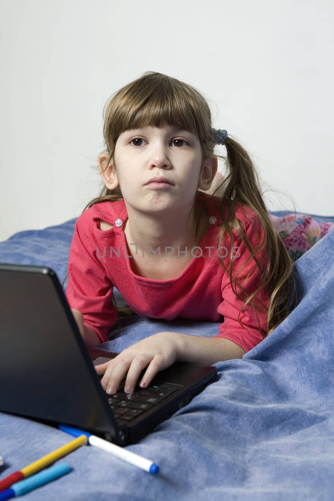 little cute girl playing on laptope by elenarostunova