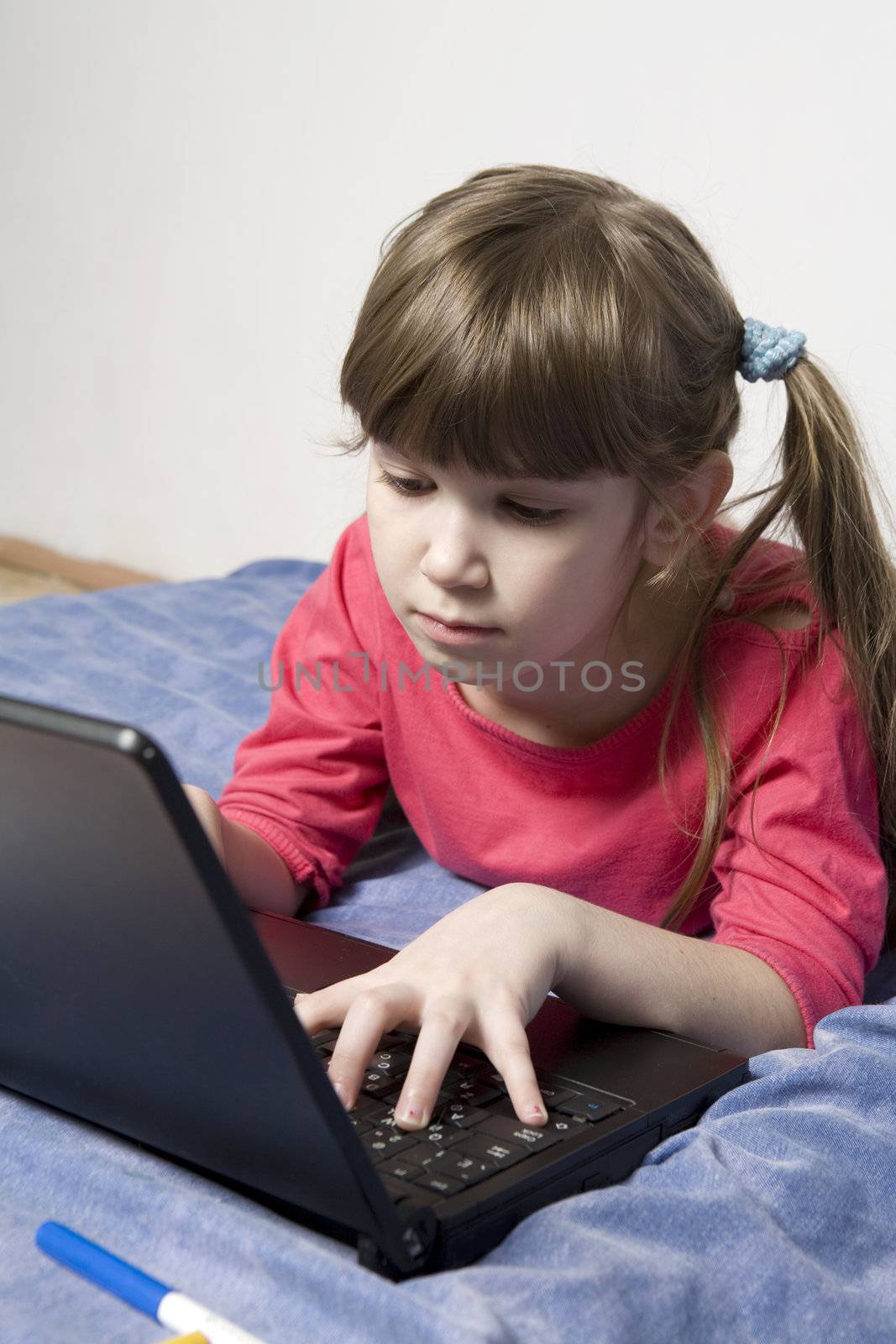 Cute little girl playing with computer by elenarostunova