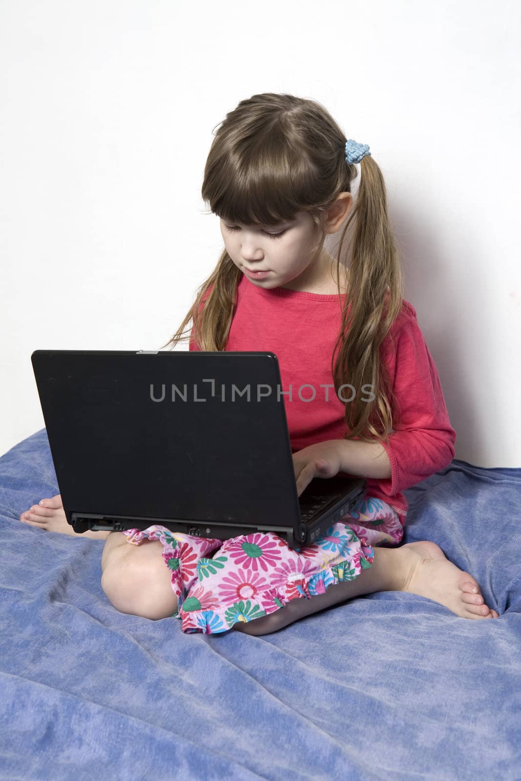 Cute little girl playing with laptop  by elenarostunova