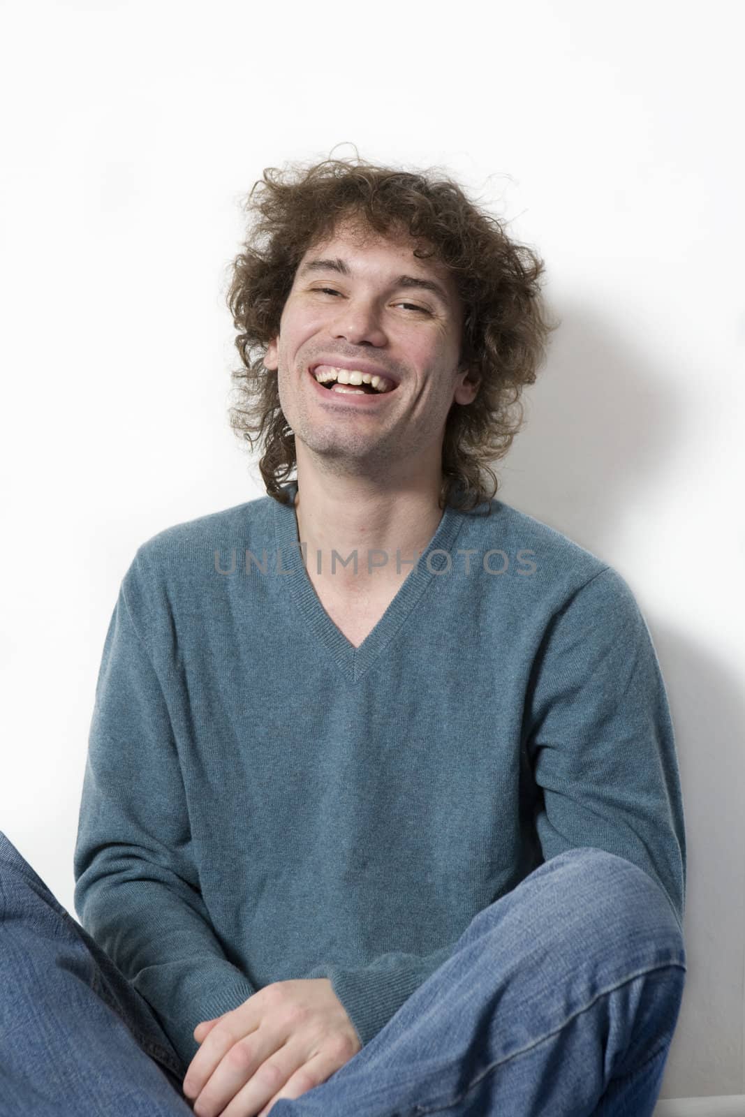 portrait middle-age smiling  curl man sitting. White background by elenarostunova