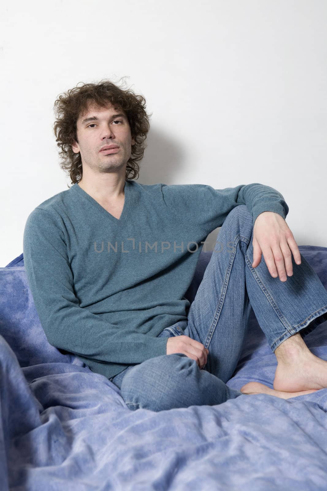 portrait middle-age serious curl man sitting. White background by elenarostunova