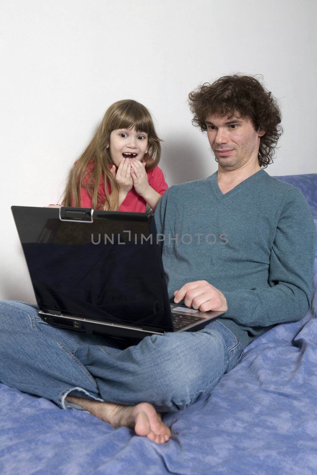 Father and daughter   using a laptop computer by elenarostunova