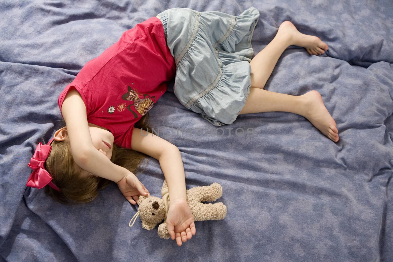 little sleaping girl in bow witn teddy-bear