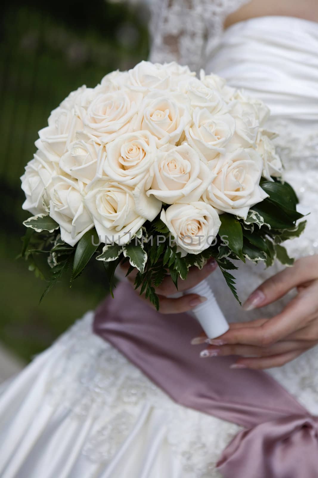 Bride in dress holding beautiful bouquet of rose