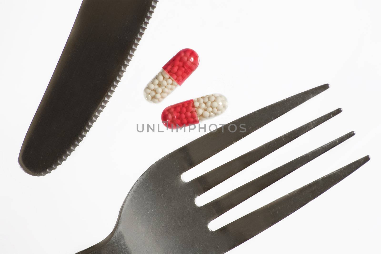 Dream about weight loss.  Fork, knife and pill. White background