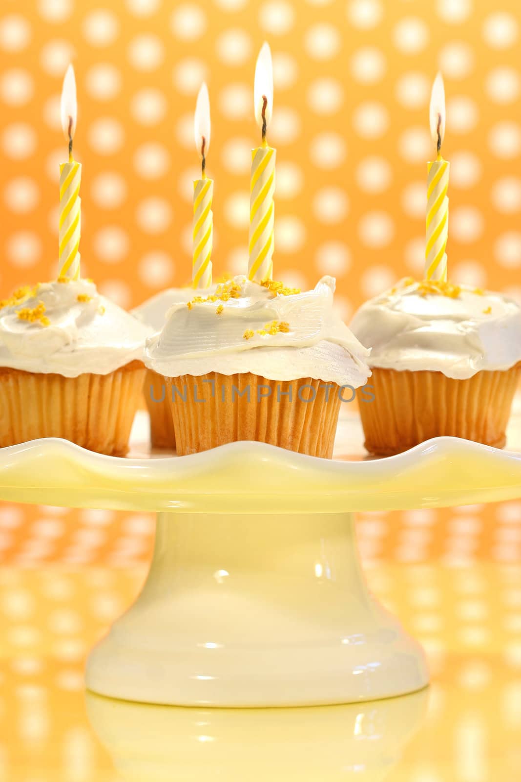 Cupcakes with orange zest sprinkled on top with polka dot background