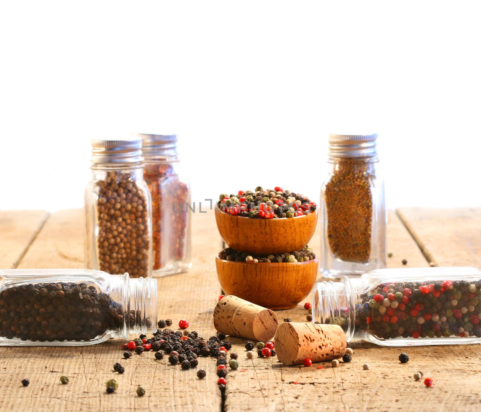 Spice glass containers on old wood table with white background