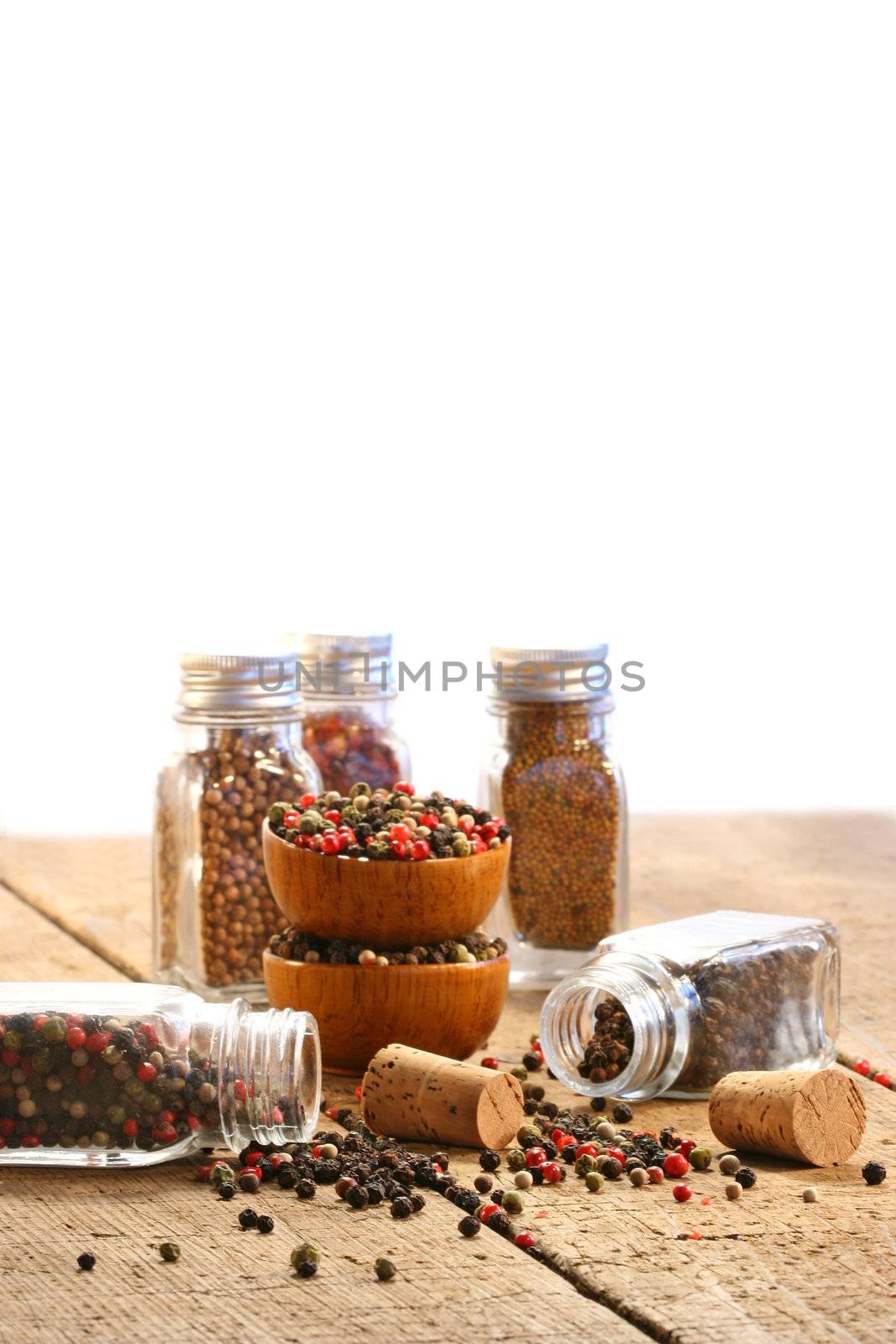 Spice bottles on rustic table with white background