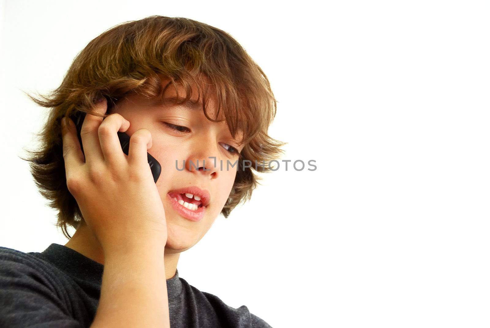 Teenage boy talking on mobile phone isolated on white background.