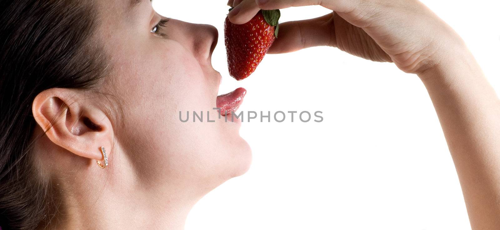 Young  woman enjoying her strawberry in a bedroom