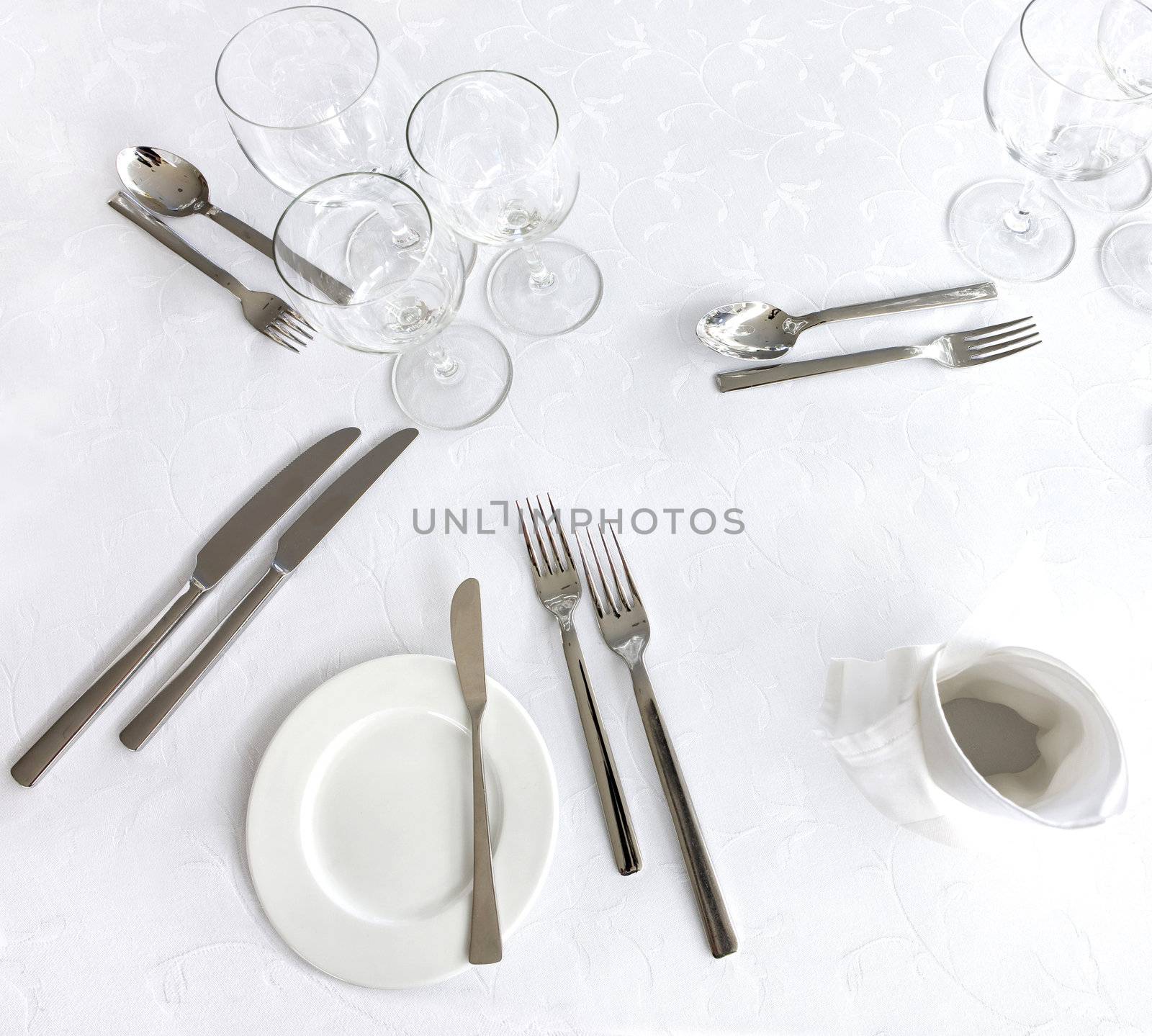 Knife, fork, spoon, plate and glasses on a table