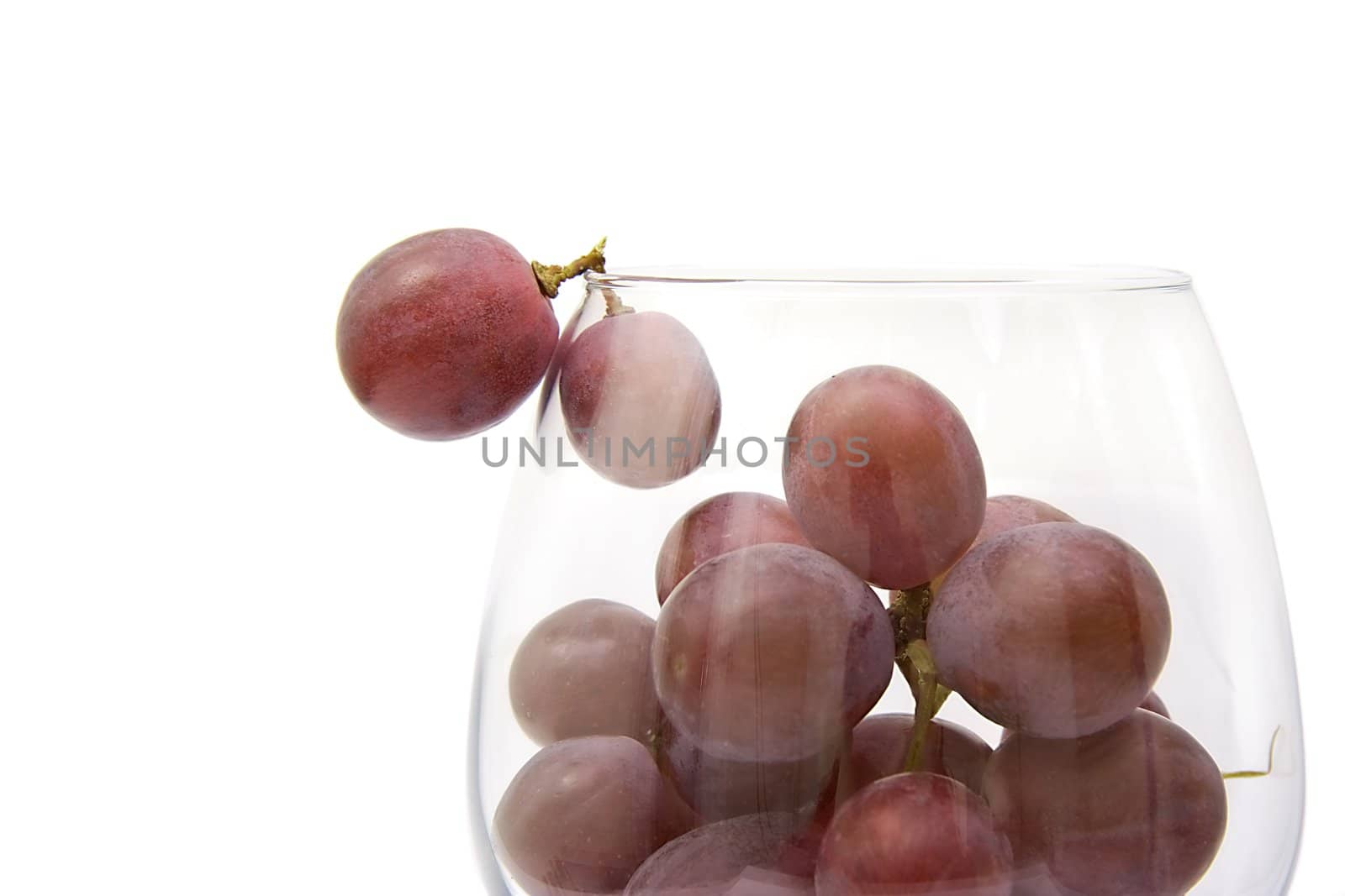 Grapes in the big wine glass on a white background