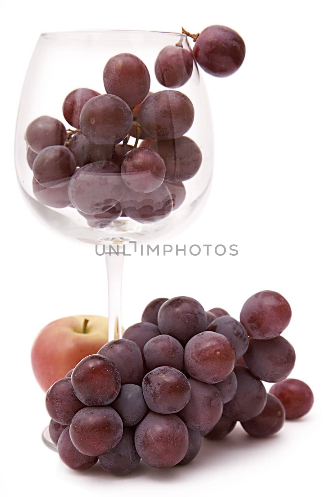 Grapes in a wine glass and an apple