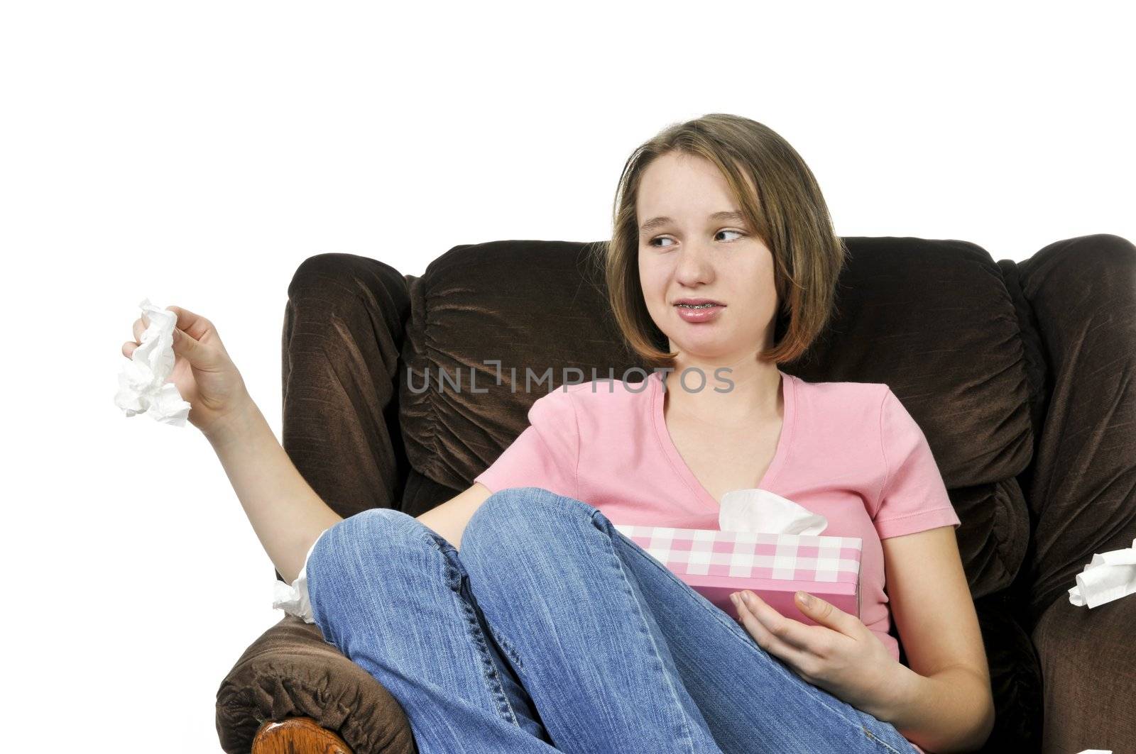 Teenage girl with a cold sitting in a chair with tissue box