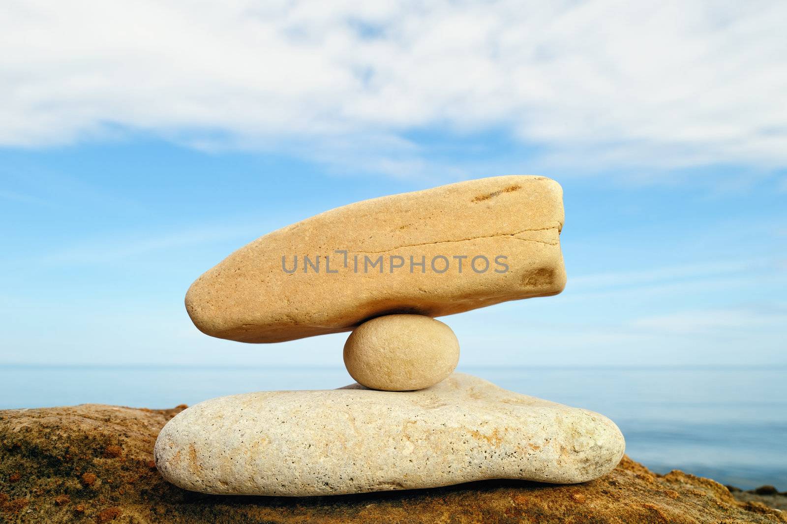 Small white pebble between two stones on the seashore