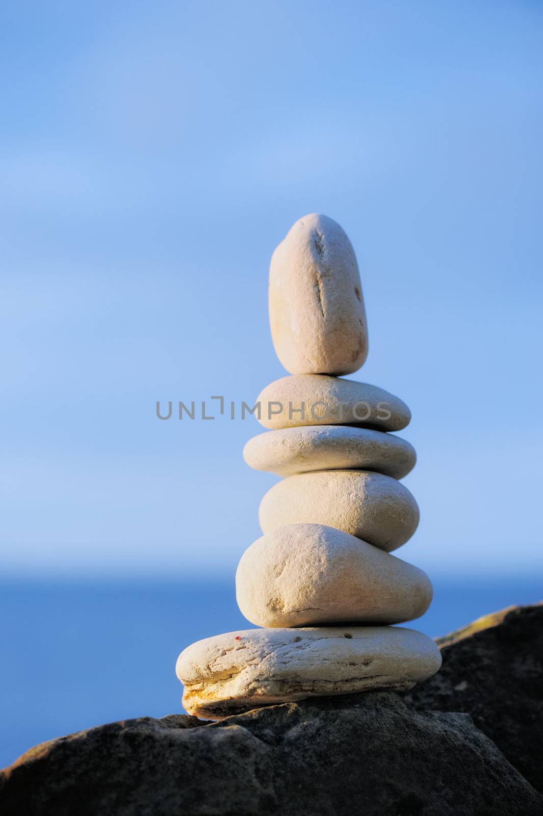 Balancing of white pebbles on the sea coast