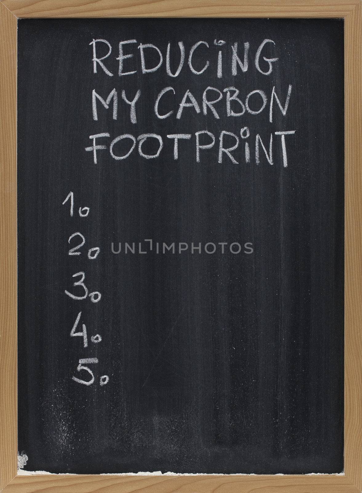 reducing my carbon footprint title and a blank numbered list of personal goals, actions or resolutions, handwritten with white chalk on blackboard with eraser smudges