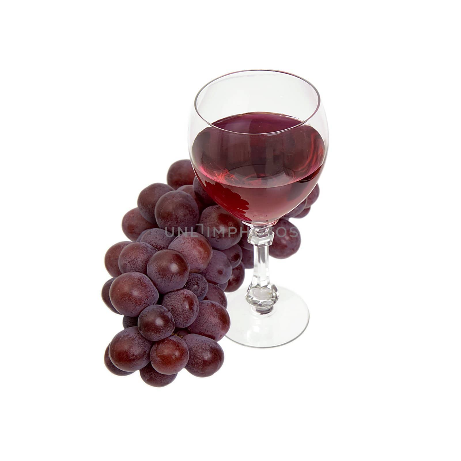 Red grapes and glass with wine on a white background