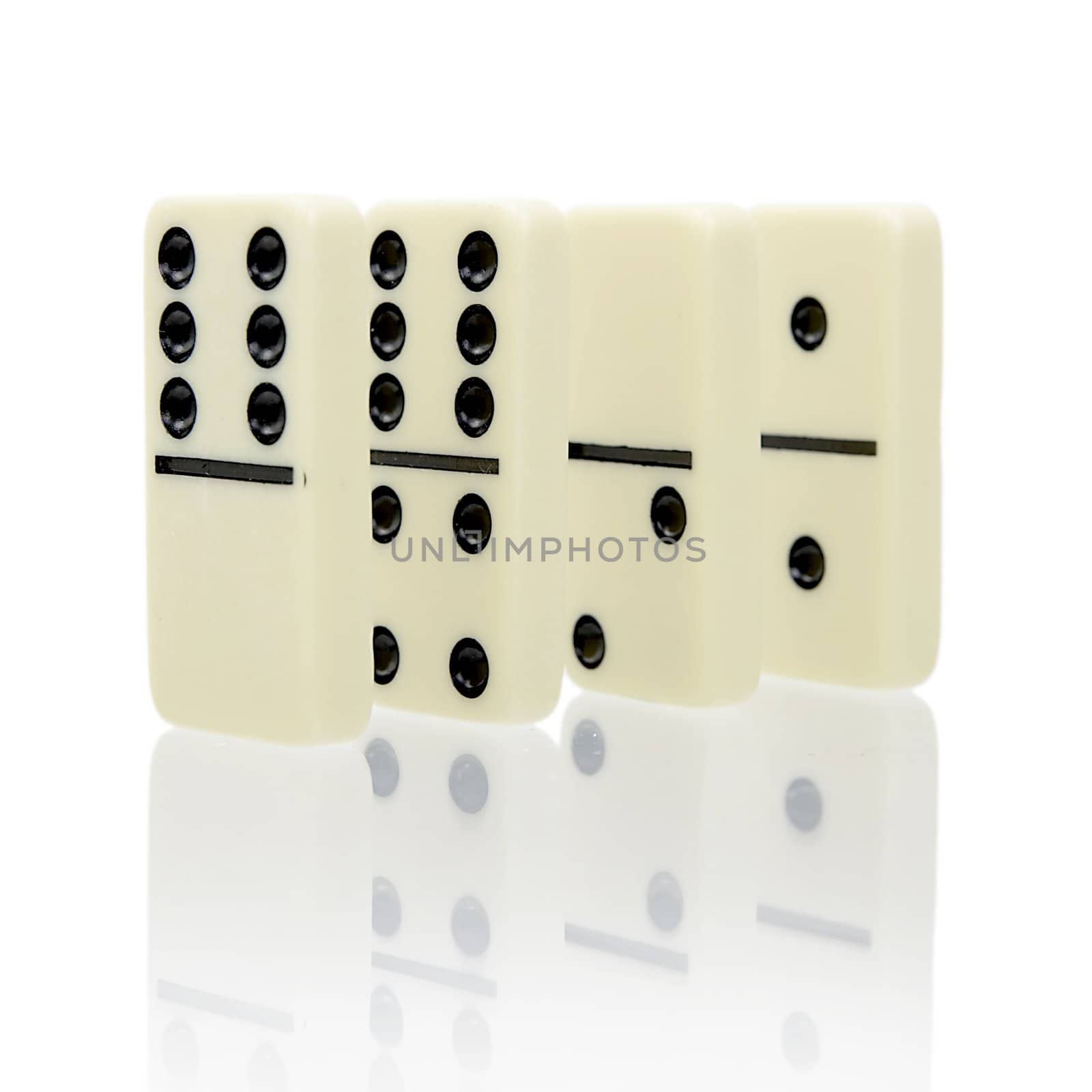 Four dominoes stand on a white background