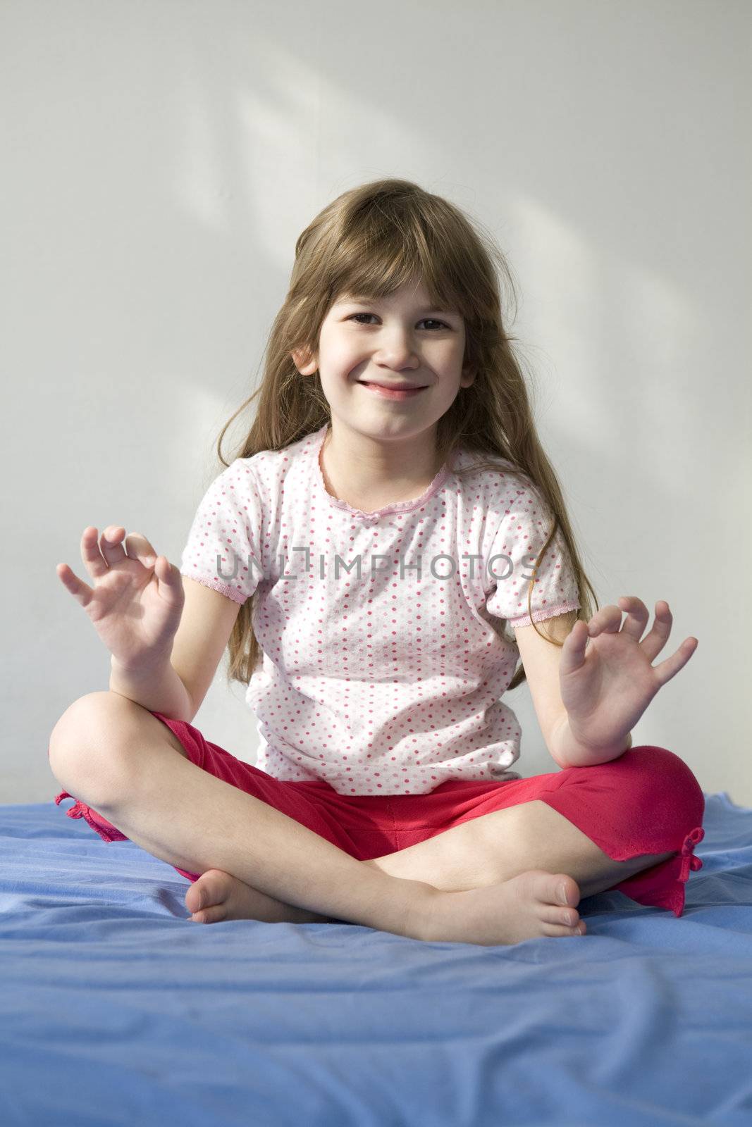 Young smiling girl  doing yoga moves or meditating. You can use  by elenarostunova