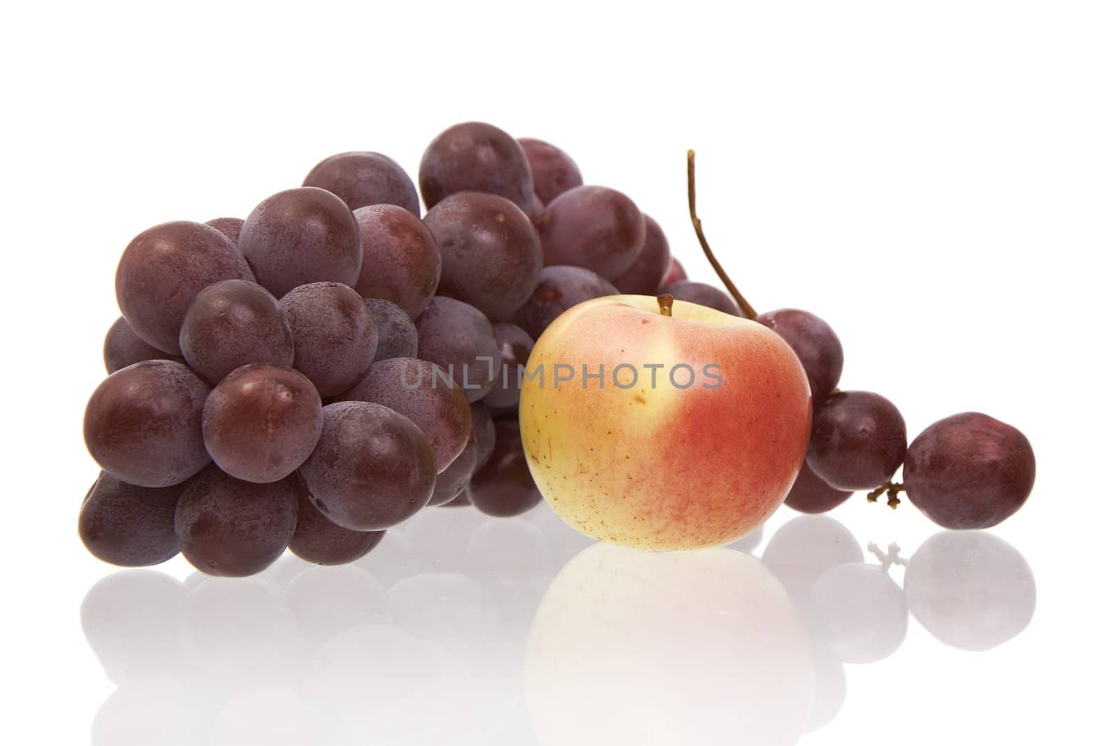 Apple and dark grapes on a white background