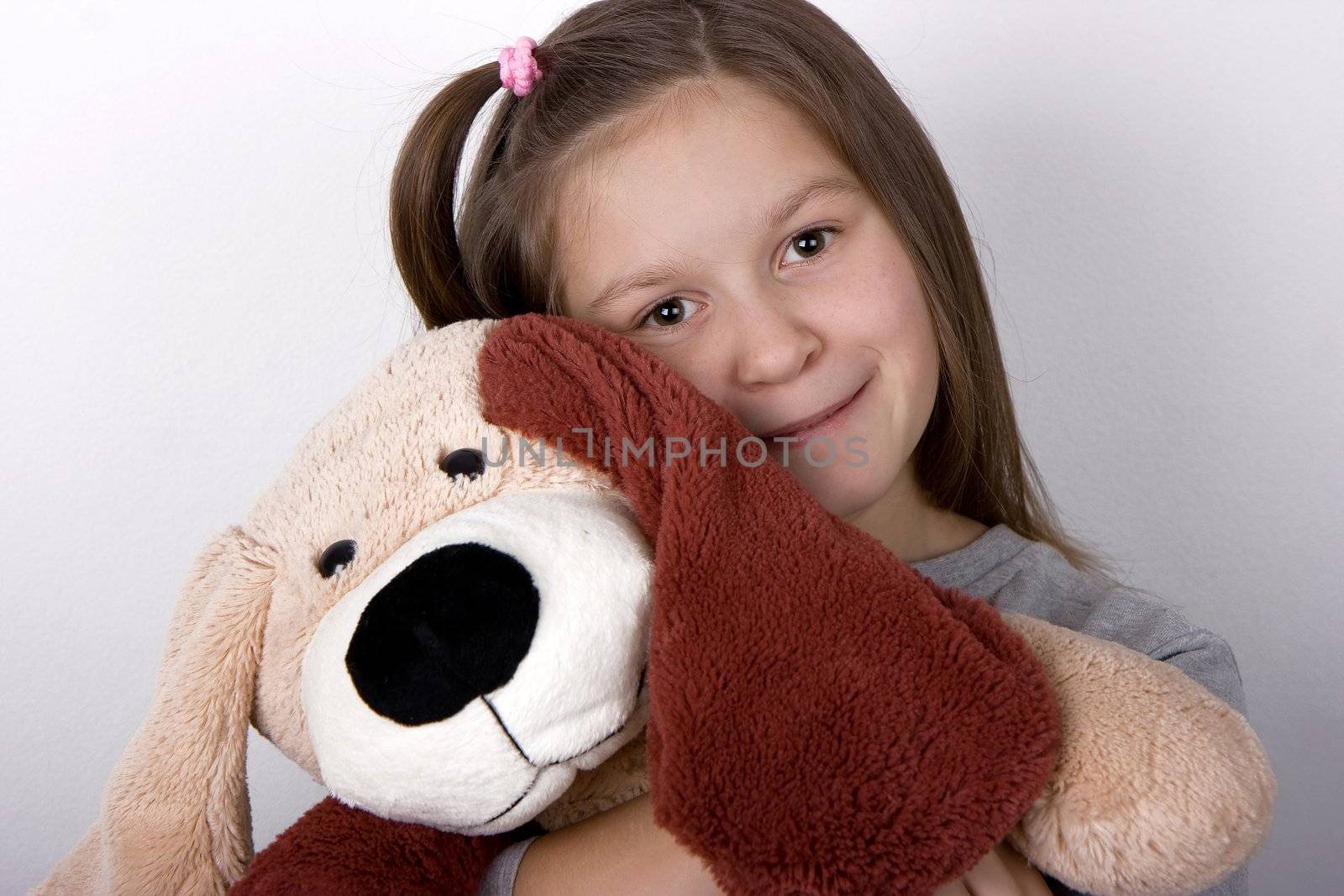 The happy girl embraces a toy dog