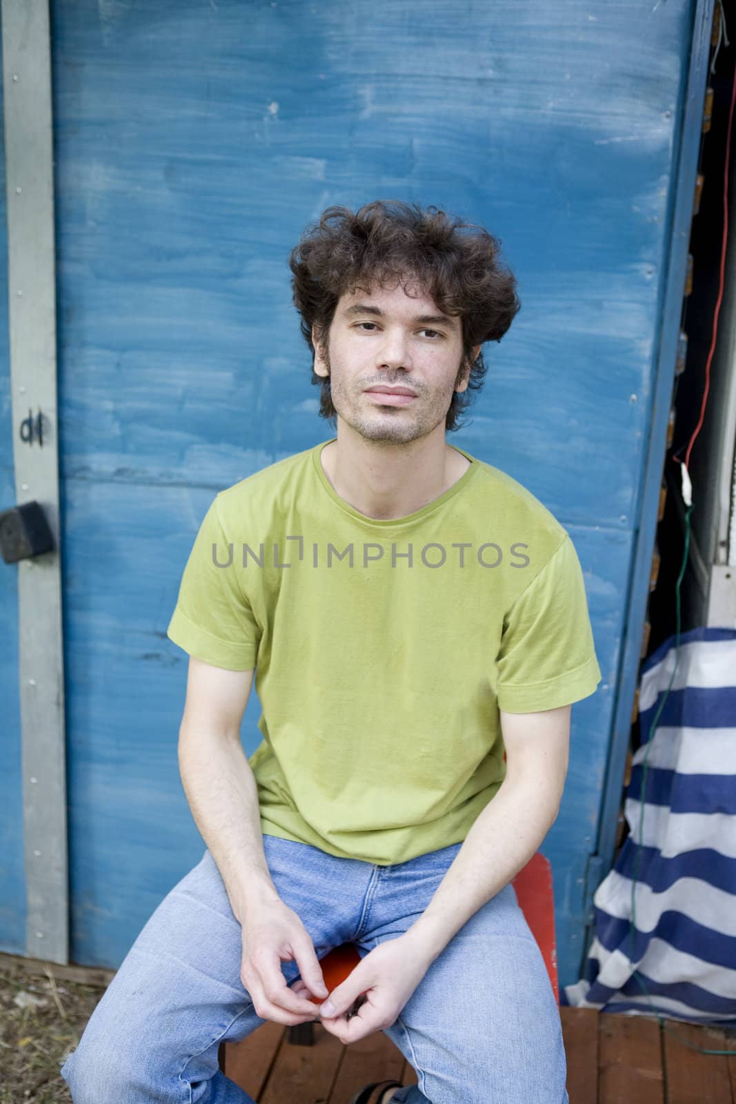 portrait young gloomy curl man middle-age sitting on chair