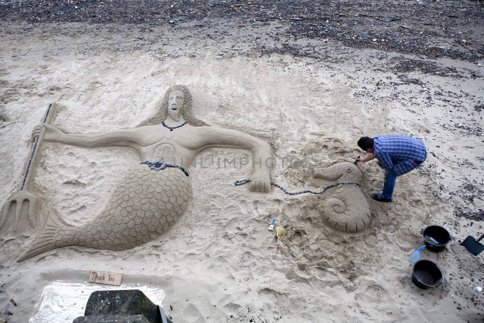 Thames. Neptune. Man build sculpture from sand