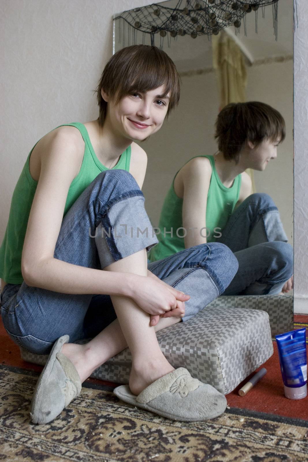 young smiling teen gir sitting at mirrow and l looking at camera
