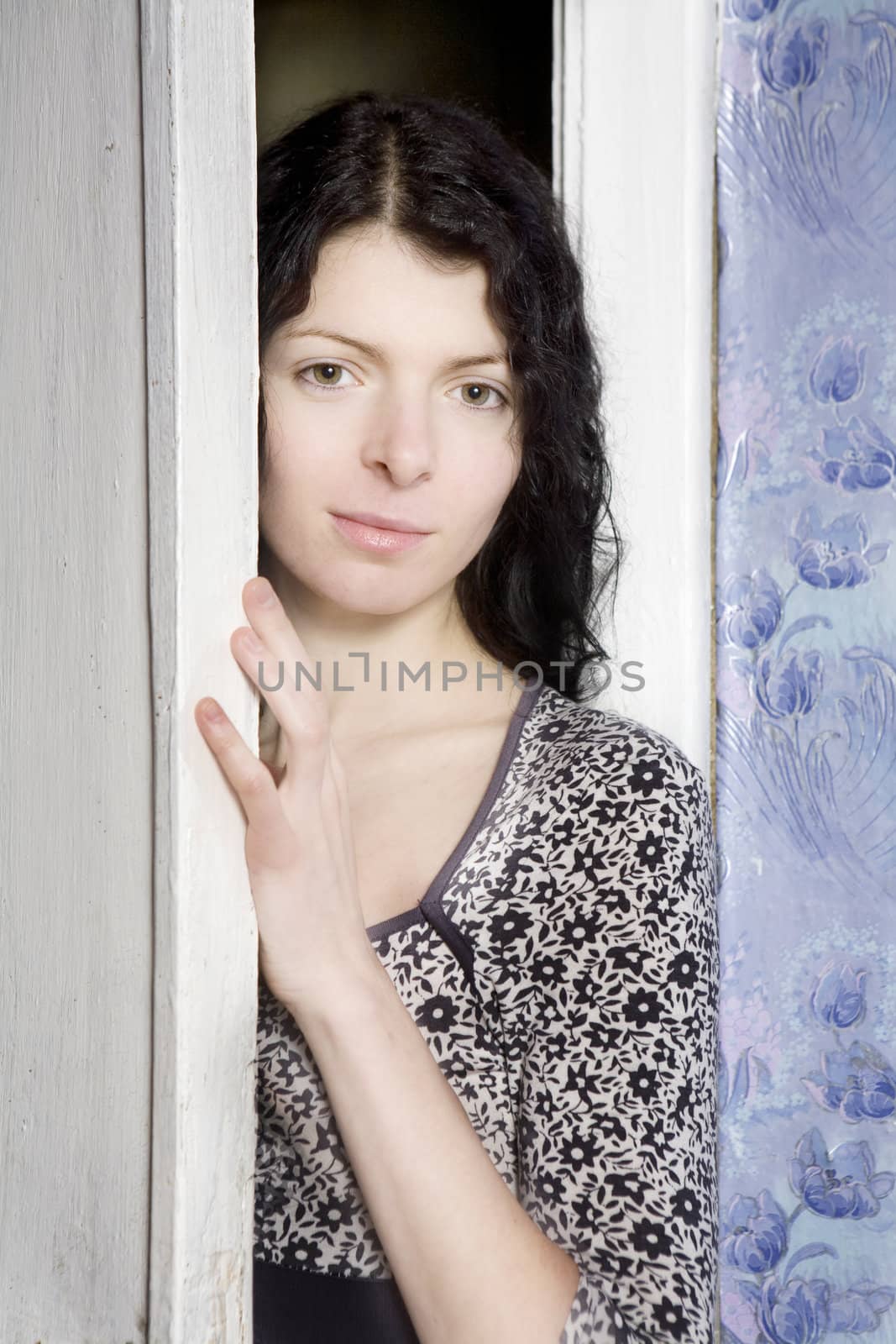 Young curl attractive woman looking through the door