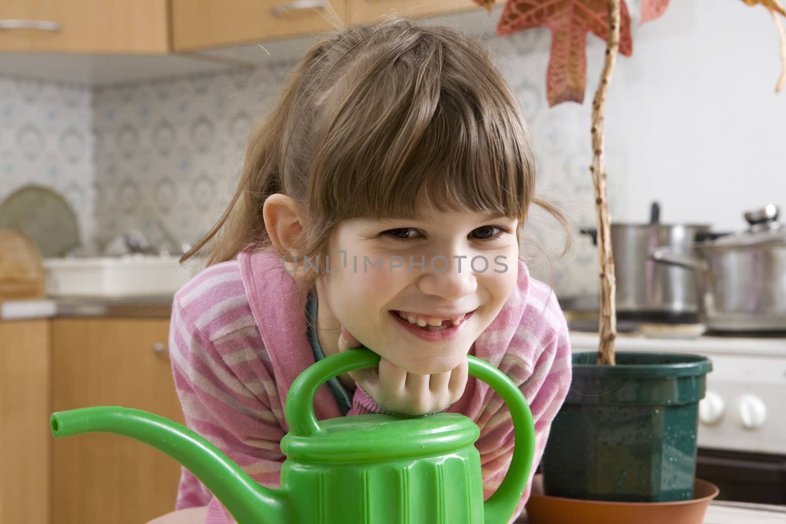  girl seven years old with watering-can sitting on kitchen by elenarostunova