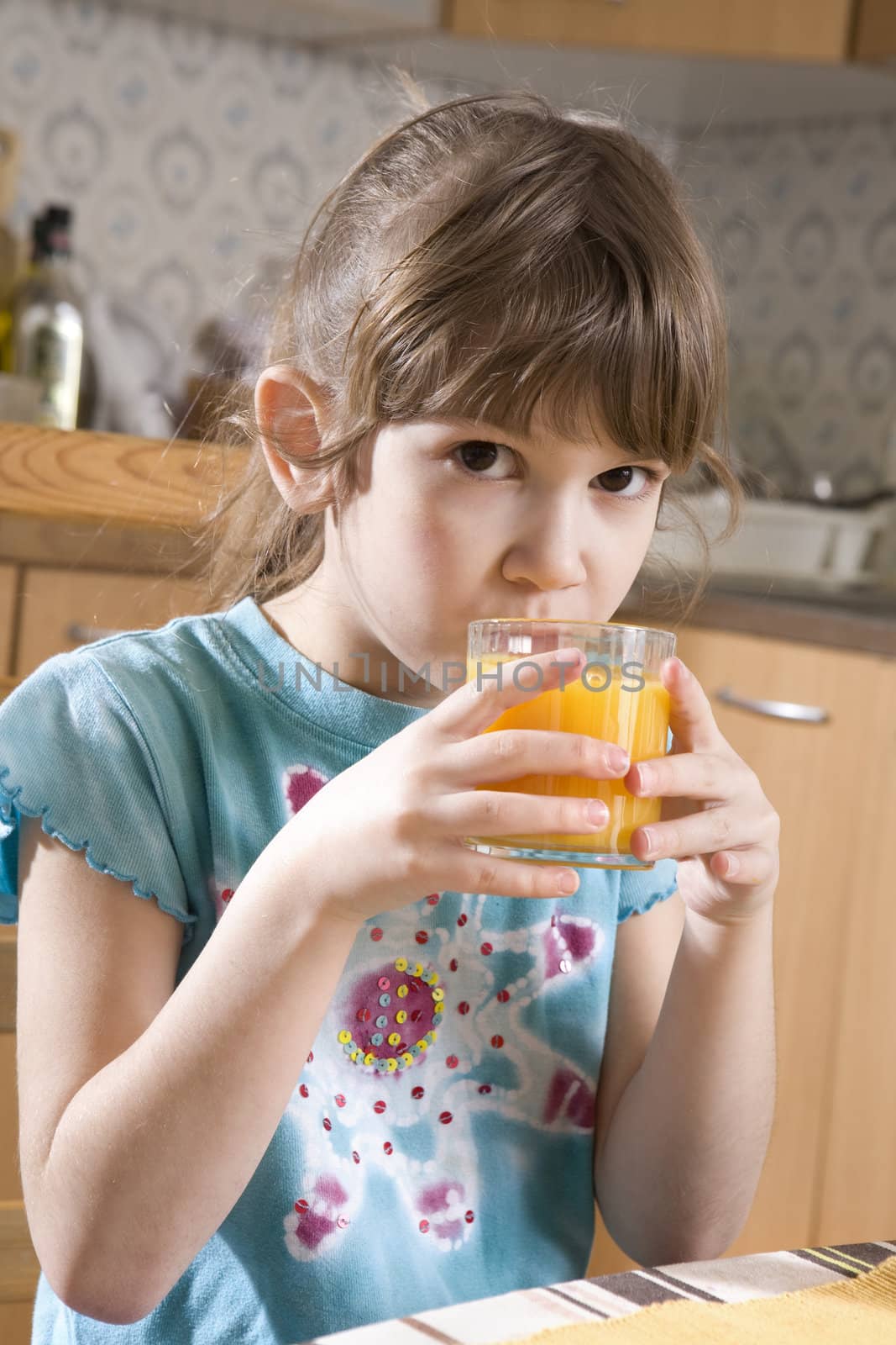 dorable serious girl seven years old drink orange juice by elenarostunova